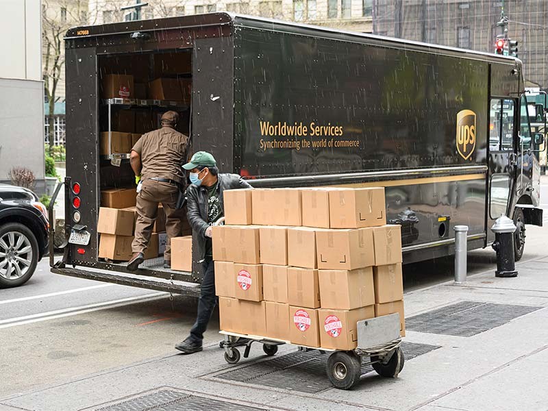 UPS delivery vehicle and busy worker in the city during COVID times