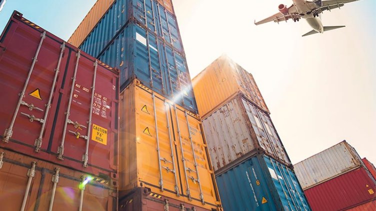 Airplane flying above cargo container