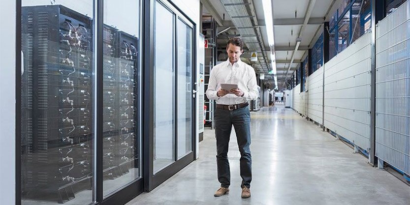 Businessman using tablet in modern data center.