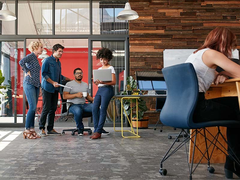 Group picture of JLL employees discussing something at the workspace