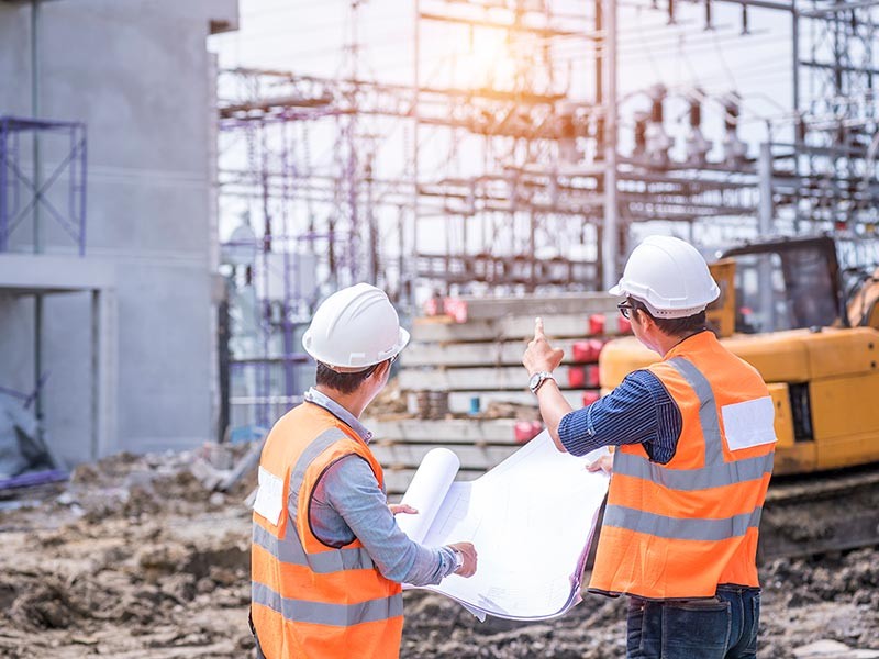 Two men with hard hats on a construction site.