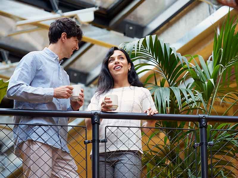 A man and woman holding coffee mugs