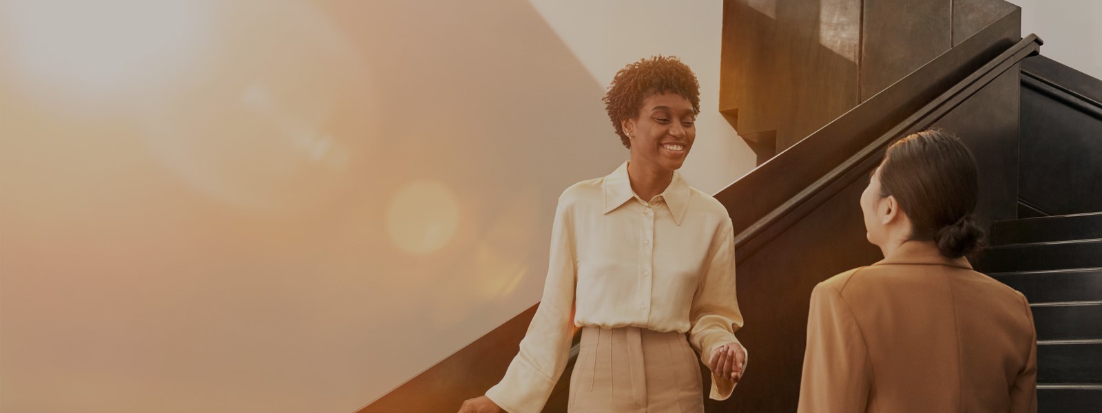 Business women talking on stairwell