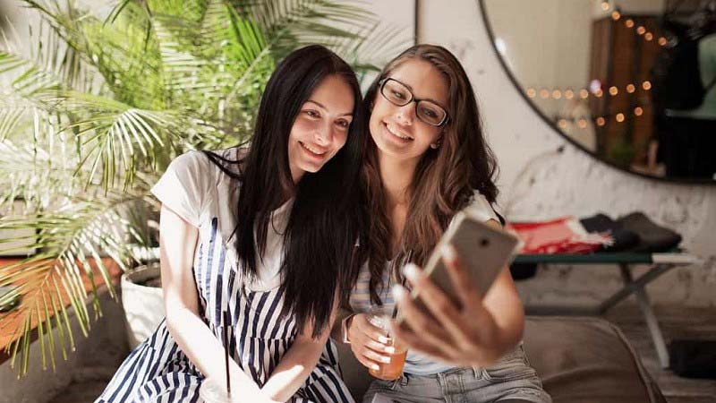 Two girls taking selfie together from their mobile