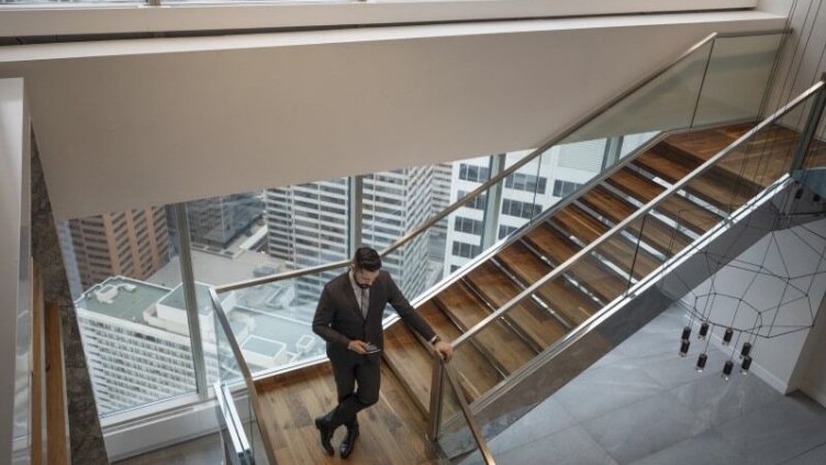 Buisnessman standing on staircase while using his phone