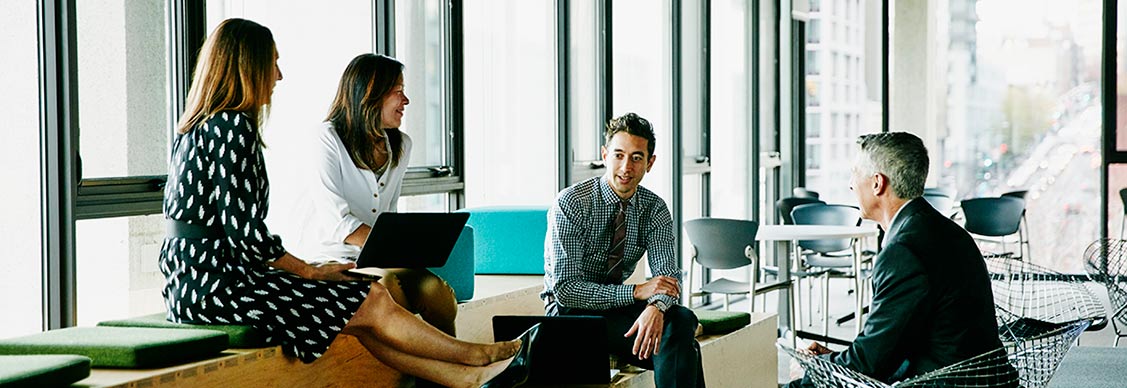 Colleagues meeting and collaborating in an informal office gathering space